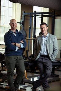 Two UA professors pose for a photo in an exercise lab.